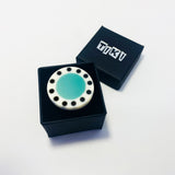 The teal blue abstract statement ring displayed in its Tiki gift box, ready to offer.