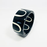 sixties patterned monochrome bangle with white polka dots on one edge