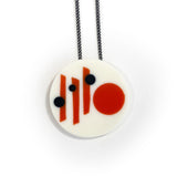 Large circular white resin pendant cast in a Midcentury Modern design of orange stripes and black polka dots. Hung on oxidised silver chain.