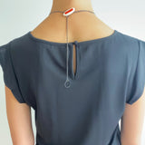 Back of the necklace with leaf shape resin and silver clasp. Worn by model.