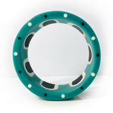 Shot of the edge of the abstract pop cuff, displaying the black and white polka dots design, inlaid in the teal blue resin.