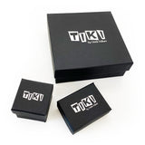 Display of various sizes of black Tiki boxes, embossed with the Tiki logo in silver.