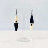 asymmetrical long diamond shaped earrings in a minimalist design of black and white resin. Hung on oxidised sterling silver.