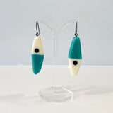 asymmetrical long diamond shaped earrings in a minimalist design of teal, black and white resin. Hung on oxidised sterling silver.