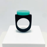 black resin finger ring fitted with a minimalist teal blue disc