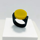 black resin finger ring fitted with a minimalist lime green disc