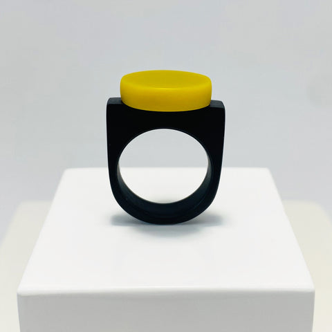 black resin finger ring fitted with a minimalist lime green disc