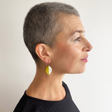 Woman wearing a leaf shaped green and white earring