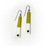 Minimalist chopstick shaped earrings cast in olive and white resin, inlaid with a black dot. Fitted with oxidised silver hooks.