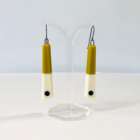 Minimalist chopstick shaped earrings cast in olive and white resin, inlaid with a black dot. Fitted with oxidised silver hooks.