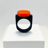 black resin finger ring fitted with a minimalist orange disc
