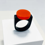 black resin finger ring fitted with a minimalist orange disc