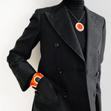 statement orange resin pendant and cuff bracelet worn by model