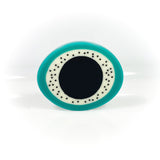 Sculptural oval shaped statement brooch cast in teal, white and black resin, inlaid with black dots.
