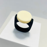 black resin finger ring fitted with a minimalist white disc