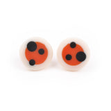 Orange circular studs with white edge, inlaid with black polka dots