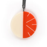 Modernist circular pendant cast in orange  and white resin. Fitted on a 60cm oxidised Sterling silver chain.