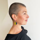 model wearing the long version of the Lunula drop earrings, handmade from mustard and black resin