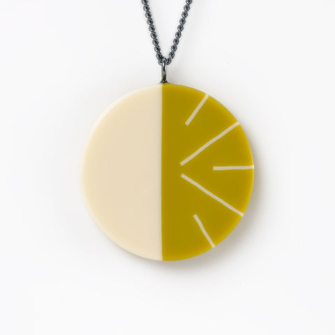 Modernist circular pendant cast in lime green  and white resin. Fitted on a 60cm oxidised Sterling silver chain.