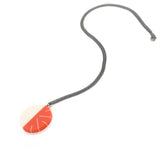 Modernist circular pendant cast in orange and white resin. Fitted on a 60cm oxidised Sterling silver chain.