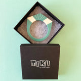 Teal Blue and White Art Deco bracelet displayed in Tiki gift box. The black box is inlaid with the Tiki logo in silver foil.