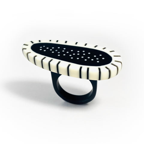 an abstract shaped chunky statement ring cast in black and white resin, inlaid with stripes and polka dots