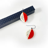 Leaf shaped resin earrings cast in orange and white resin, and inlaid with black polka dots. Fitted with oxidised silver hooks.