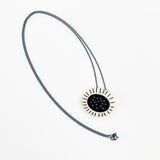 Necklace with a sun-shaped pendant on a white background