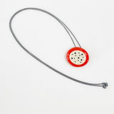 Necklace with an orange and white pendant on a white background