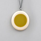 reversible mustard green and white pebble shaped resin necklace, hangs on oxidised silver chain
