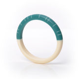 The beautiful modernist Lunula slim bracelet, cast in resin and hand sanded to a lovely smooth tactile finish. One half is cast in plain creamy white, the other oil a gorgeous teal and inlaid with contrasting white lines.