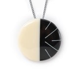 Lunula circular pendant handmade from black and white resin and Sterling silver. The modernist Lunula motif consists of one plain cream half, the other is black, inlaid with contrasting lines in white. It hangs on a 70cm Sterling silver oxidised chain.