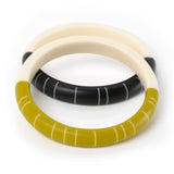 2 handmade Lunula resin bracelets. one cast in lime green and white, the other in black and white. The geometric design consists of contrasting white lines inlaid in each coloured half, whilst the white other bracelet halves are cast in plain ivory white.