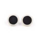 minimalist circular earrings made from white resin and inlaid with a black centre; fitted with Sterling silver pins and comfortable plastic pads backs. 