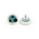 Turquoise blue and white circular stud earrings handmade from resin. The surface is decorated with black polka dots. 