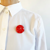 Midcentury Modern Zazou brooch, handmade from orange and white resin, worn by model on white shirt
