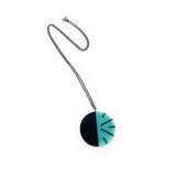 Teal blue and black circular pendant, handmade from resin and inlaid with the Lunula modernist motif. On long oxidised silver chain.