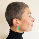 Model wearing turquoise and white Lunula disc hoop earrings.