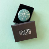Teal blue atomic style resin brooch displayed in Tiki gift box, ready to offer
