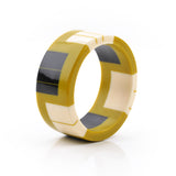 geometric bracelet cuff cast in mustard resin, inlaid with black and white stripes