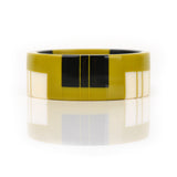 geometric bracelet cuff cast in mustard resin, inlaid with black and white stripes