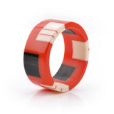 geometric bracelet cuff cast in orange resin, inlaid with black and white stripes