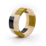 geometric bracelet cuff cast in white resin, inlaid with black and mustard stripes