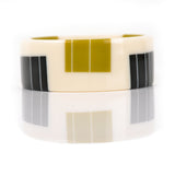 geometric bracelet cuff cast in white resin, inlaid with black and mustard stripes