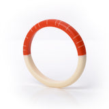 Modernist statement resin bracelet, handmade from paprika orange and creamy white resin. The minimalist design consists of two halves. One is plain white, the other is tangerine, inlaid with contrasting white lines.