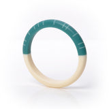 Modernist Lunula slim bracelet, handmade and cast. One half is cast in plain creamy white, the other is teal, inlaid with contrasting white lines.